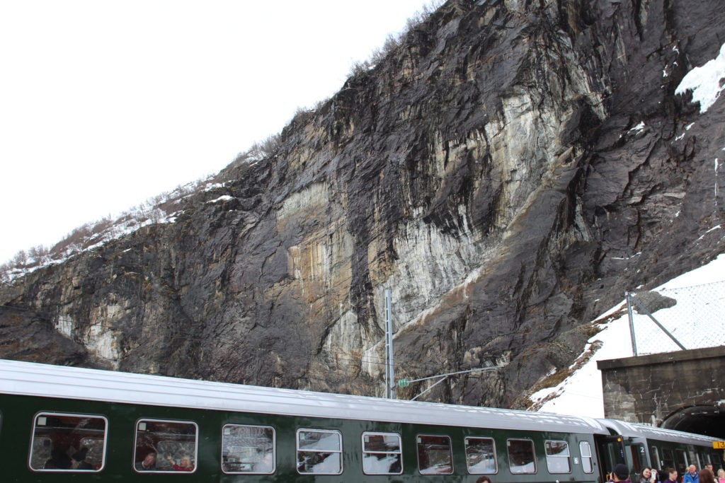 Tourists taking pictures of the beautiful views around during a railway stopover of their Norway in a Nutshell tour