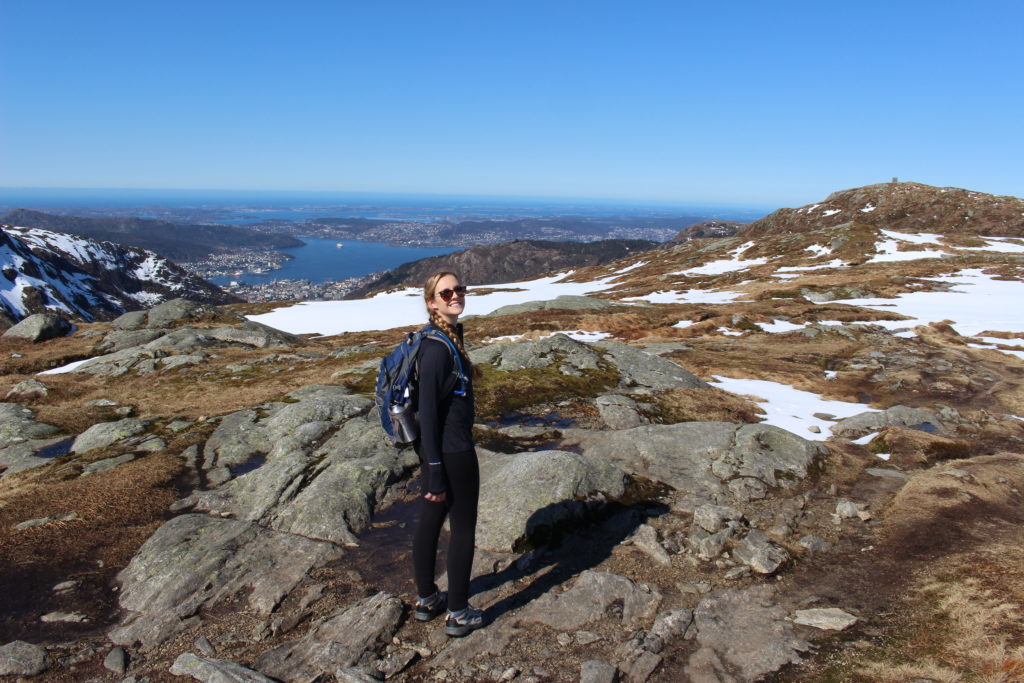 Maddy standing on rugged and snowy mountain trail in one of her best hikes in Bergen, Norway