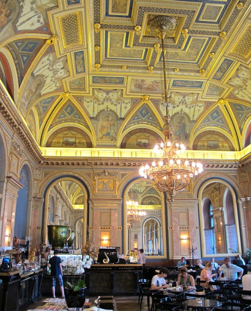 People dining in the Alexandra Bookcafé. Having your coffee break in this beautiful cafe is one of the top 25 things to do in Budapest.