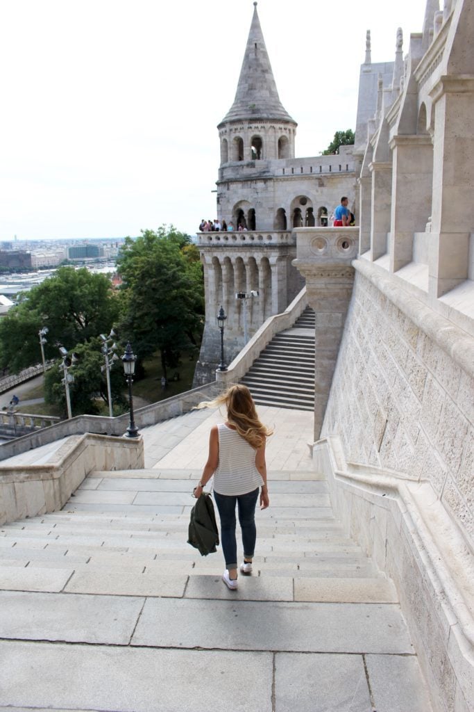 Maddy walking down the stairs in Budapest. Going solo for a few hours can also be considered even when traveling with a friend.