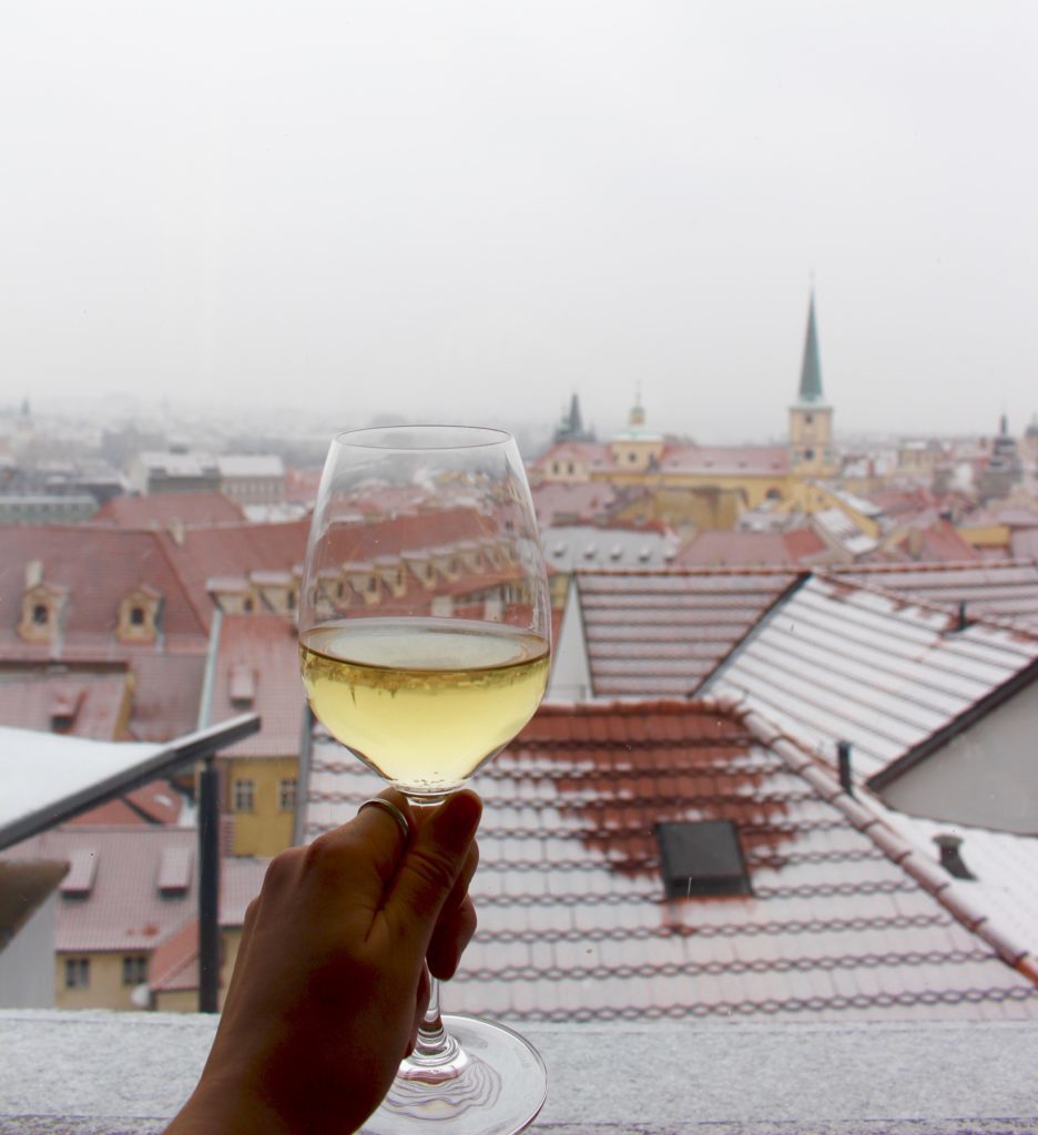 Holding a glass of Czech Sauvignon while overlooking the city of Prague