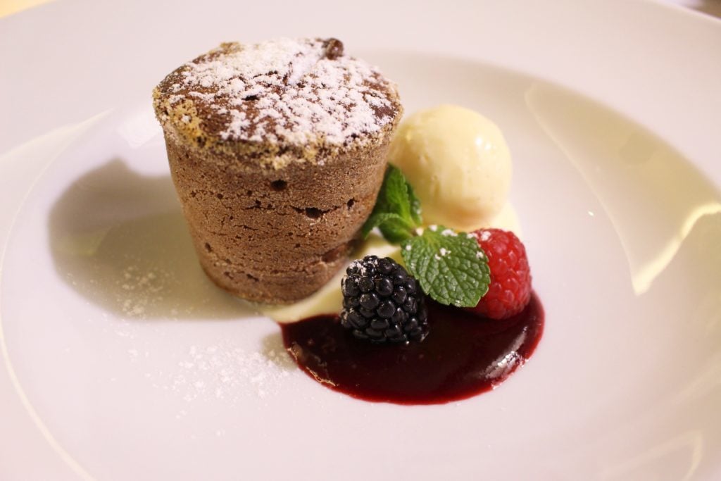 Molten chocolate cake with homemade vanilla bean ice cream and a sweet berry sauce