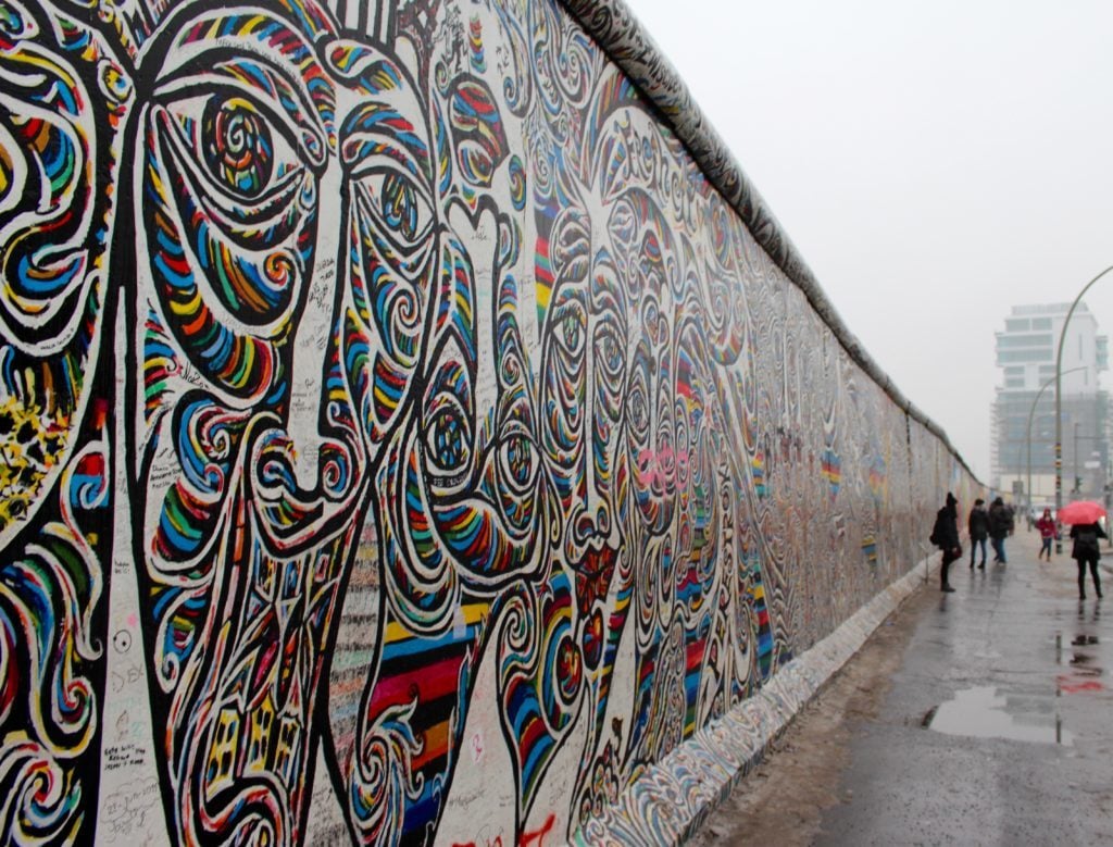 Colorful street art on a rainy day. One of the top 10 things to do in Berlin is strolling along the creative mural at the East Side Gallery.