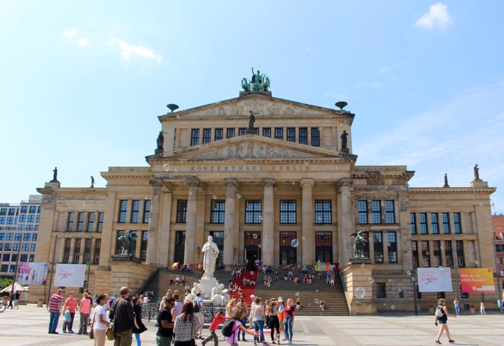 People roaming around and hanging out outside the Konzerthaus. Enjoying the stunning architecture at the Gendarmenmarkt is one of the top 10 things to do in Berlin.