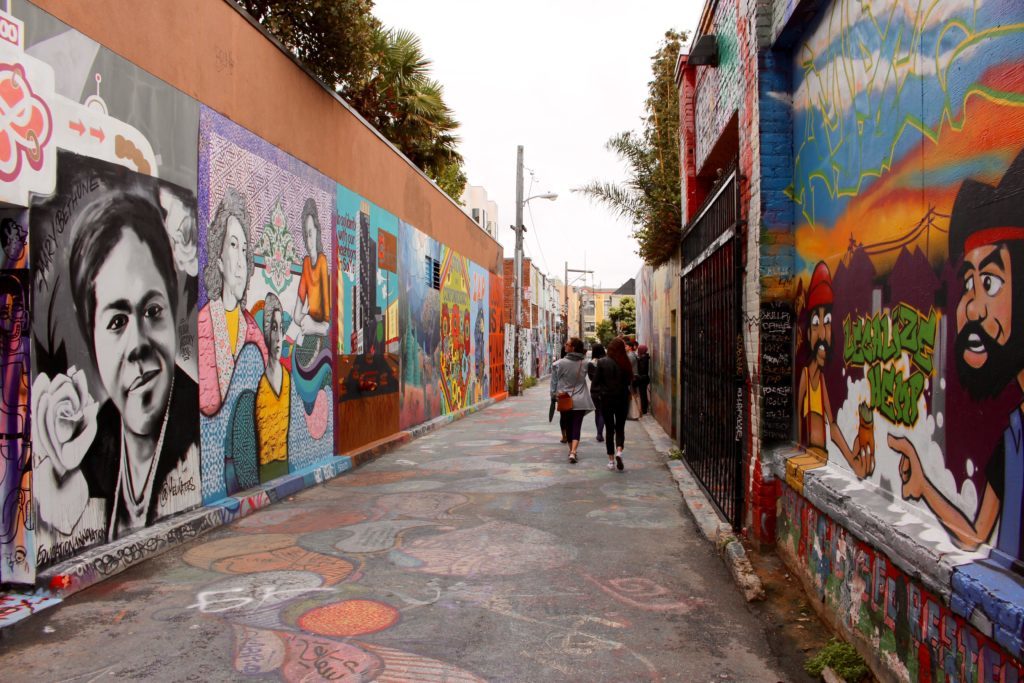People passing by the artistic murals in Clarion Alley