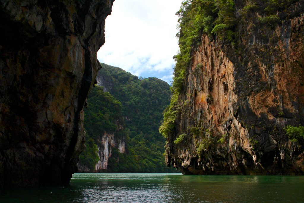 Cruising on the ocean surrounded by tall rock formations while island hopping in Thailand