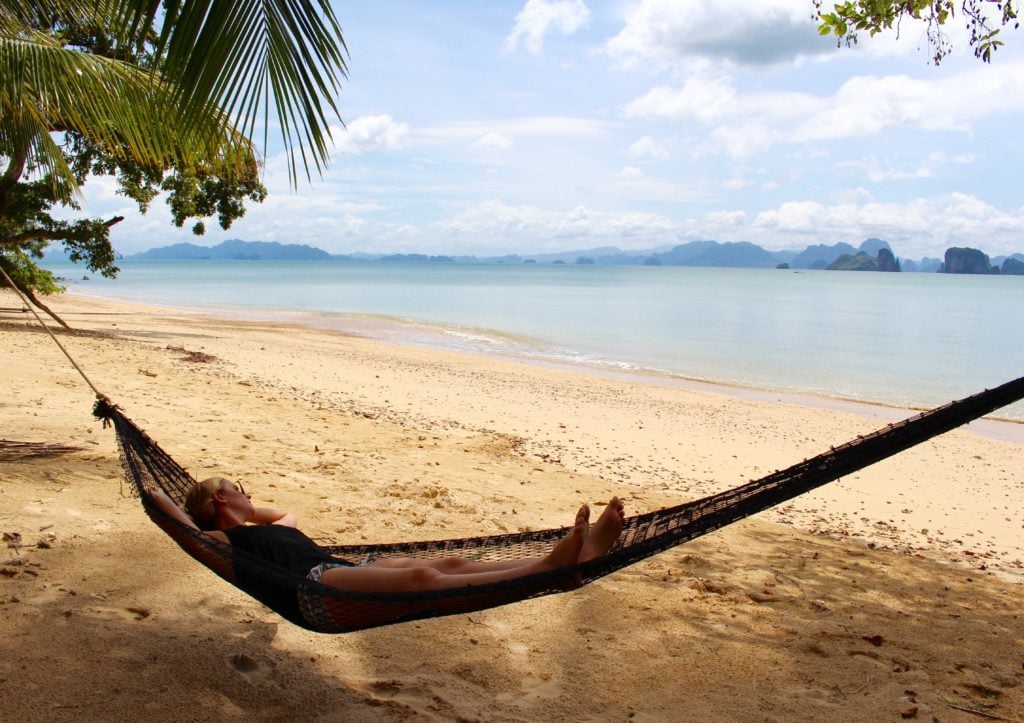 Maddy relaxing on a hammock on a sandy beach