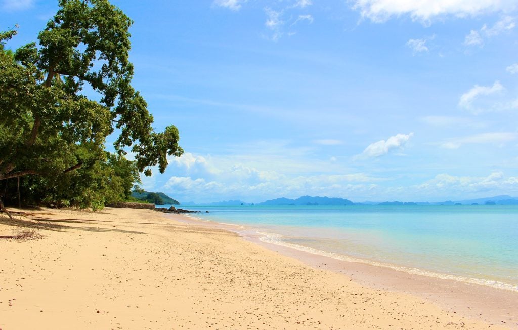 Sandy beach and blue ocean waters under the blue sky