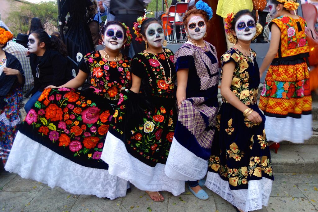 Mexican women in costumes during the Day of the Dead celebration. The Day of the Dead is one of the 20 festivals to experience in your 20s.