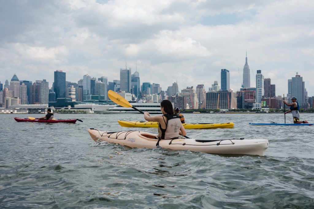 People kayaking with the NYC skyline in view - this is one of the most fun things to do in NYC