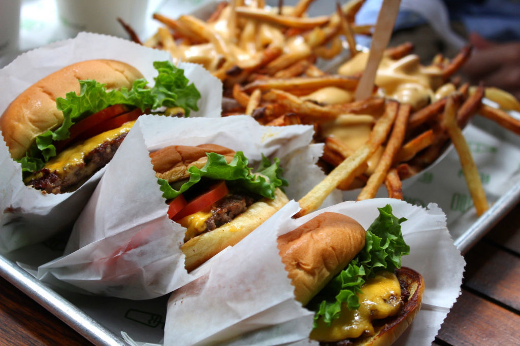 Burgers and fries on a tray from Shake Shack. Eating here is one of the best things to do in NYC.