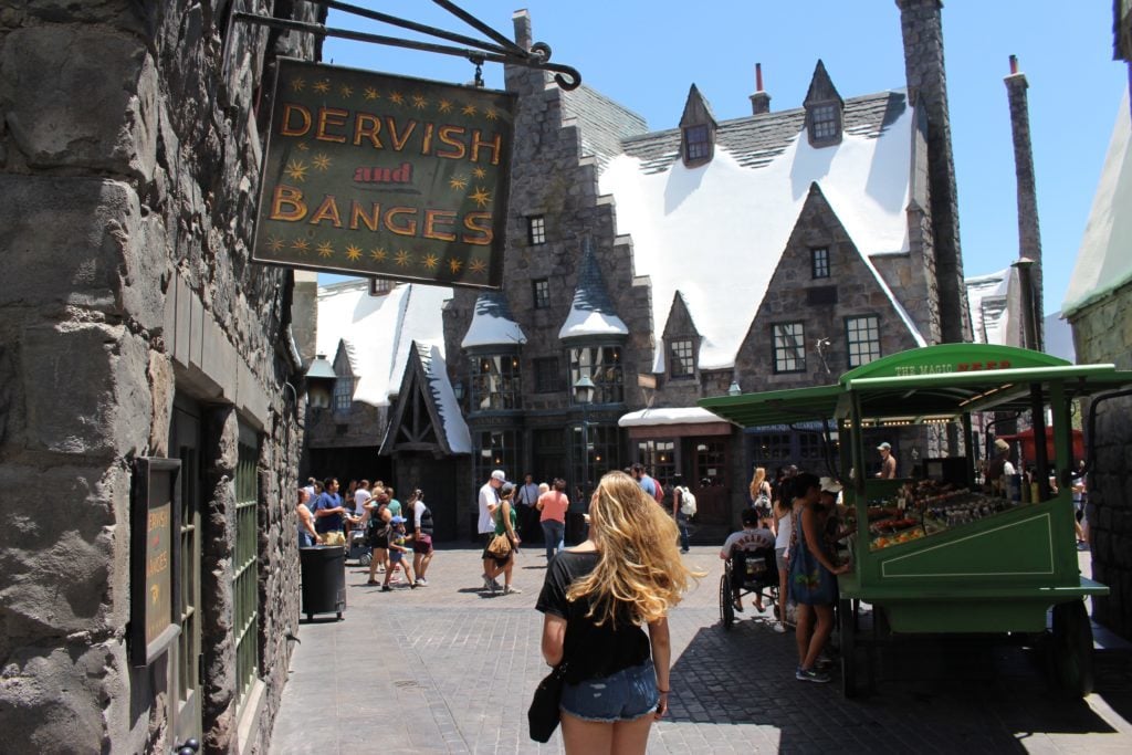 Maddy walking in front of a shop with sign "DERVISH and BANGES"