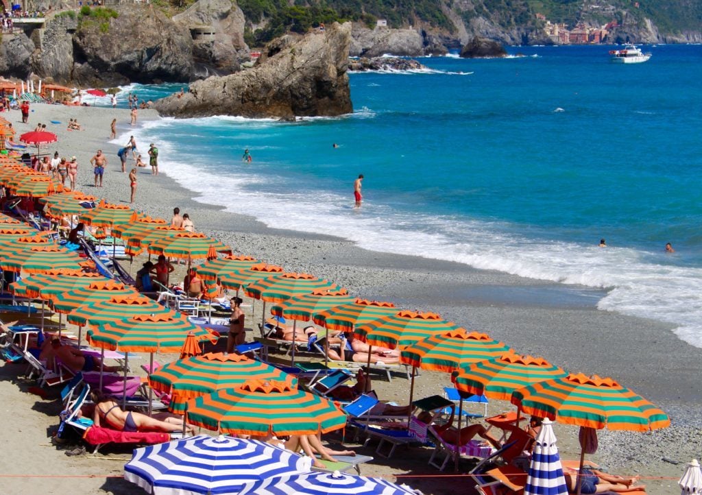 Colorful beach umbrellas lined by the beach in Monterosso