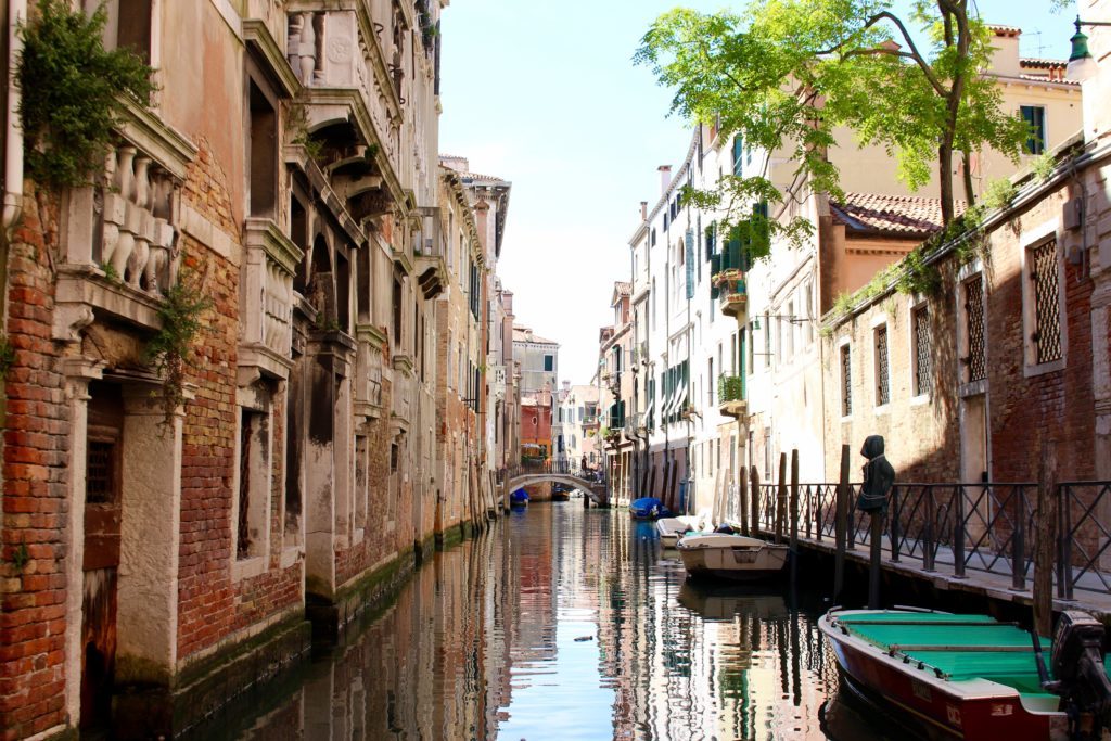 Boats docked on a narrow canal in Venice