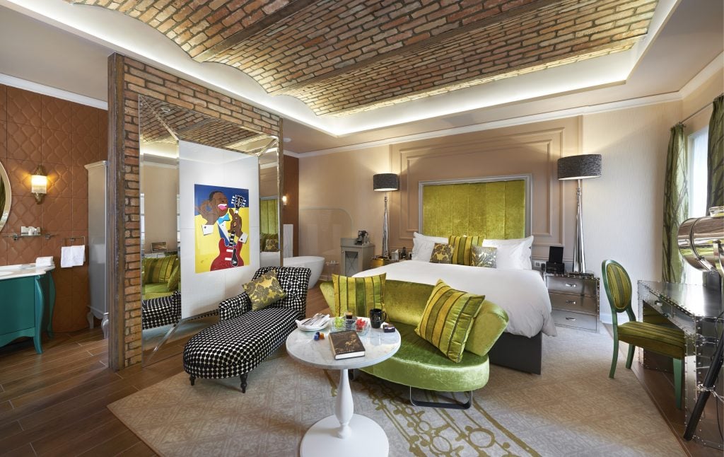 Stunning and luxurious guest room with lime green accent and brick walls