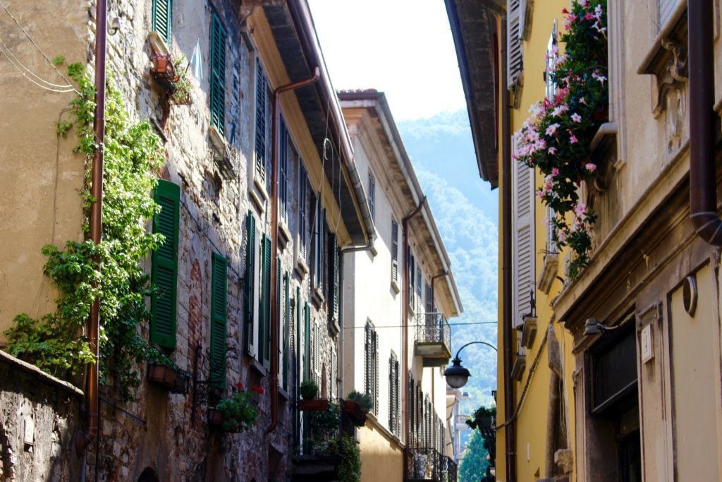 Narrow street with colorful buildings in the town of Como. In this Lake Como travel guide, you'll find the best places to stay in Como.