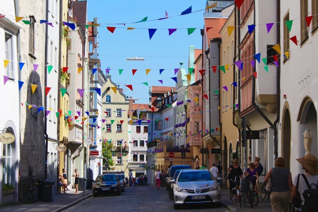 Street in Regensburg, Germany decorated with colorful banners. Regensburg is one of our destinations during our Viking River Cruises Grand European Tour.