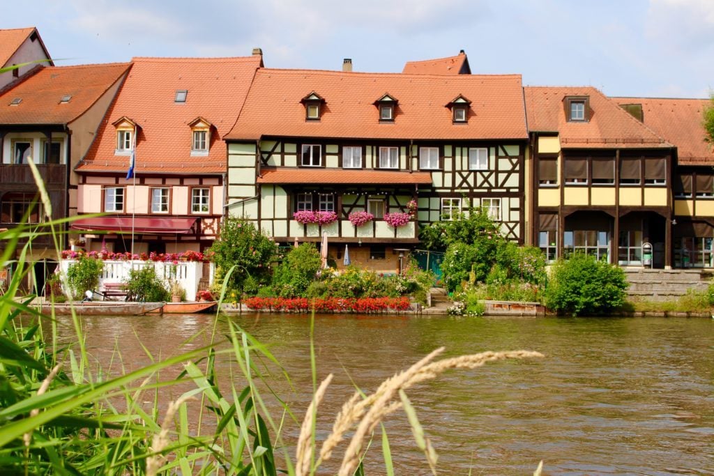 Medieval buildings by the river in Bamberg. Going on a river cruise is one of the best things to do in Bamberg, Germany.