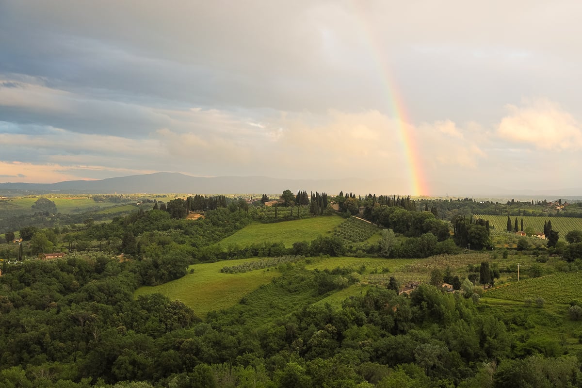 Beautiful rainbow jumping over the lush green farms of San Gimignano