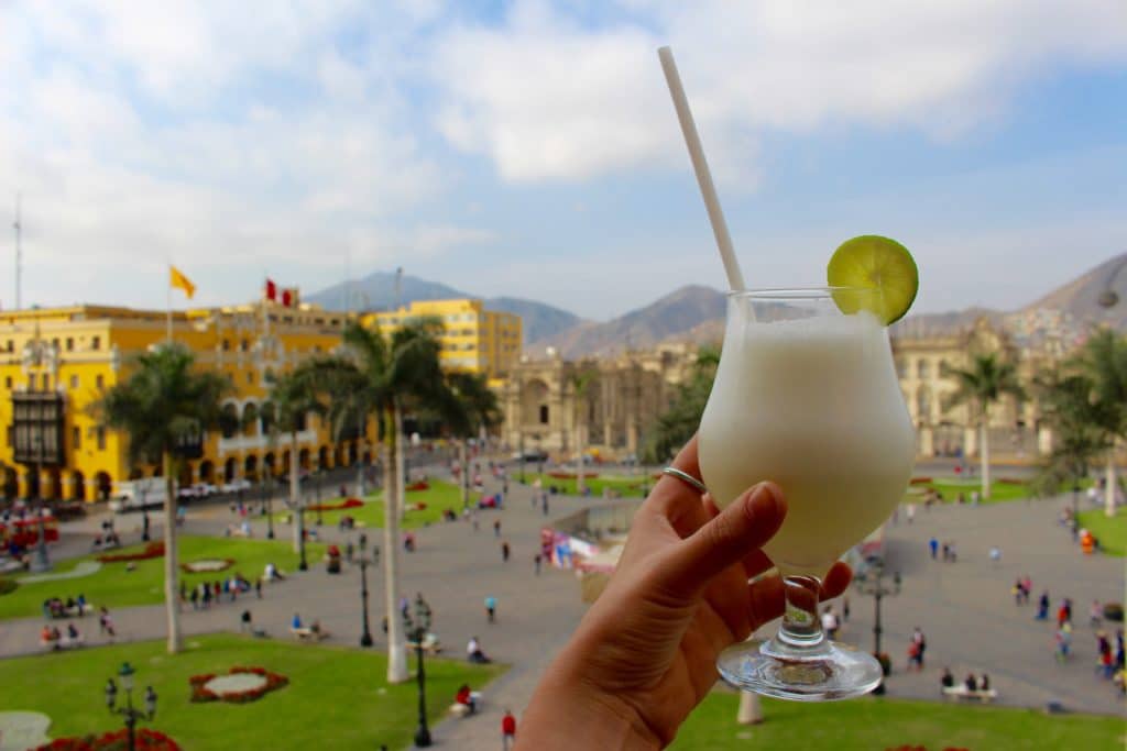Holding up a glass of Pisco Sour