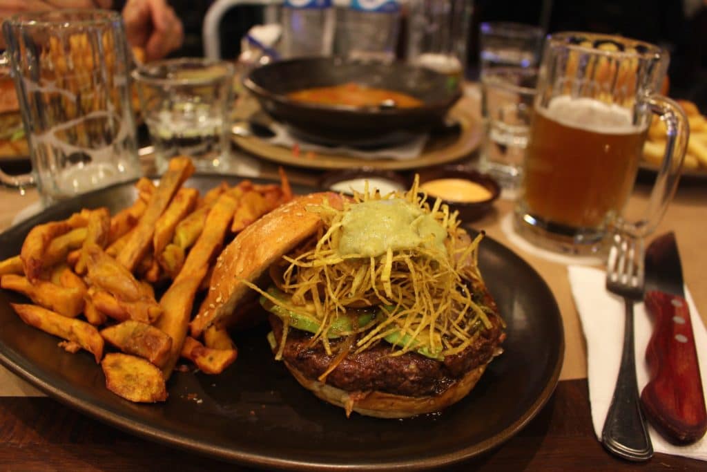 Flavorful cheeseburger and fries served with beer at Papacho's