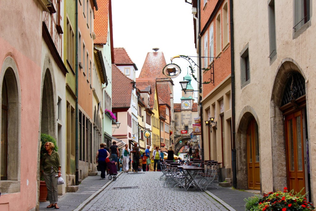 People walking along the cobblestone streets. These beautiful streets surrounded by medieval buildings are considered to be the main sights and attractions in Rothenburg ob der Tauber.