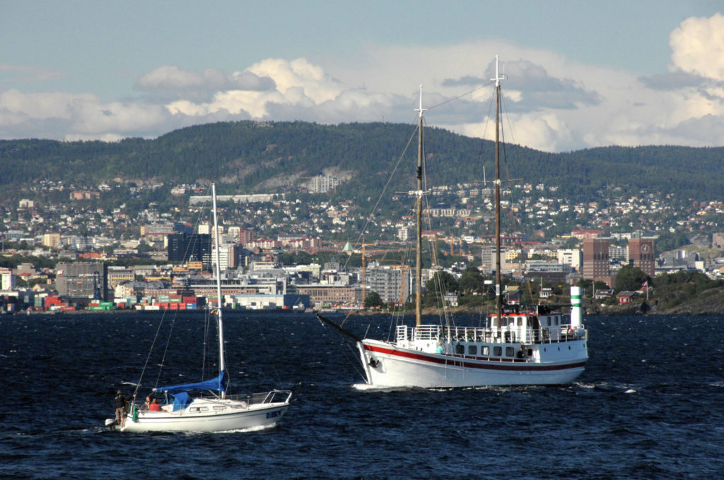 Two boats cruising in the middle of the ocean in the Oslo Region of Norway