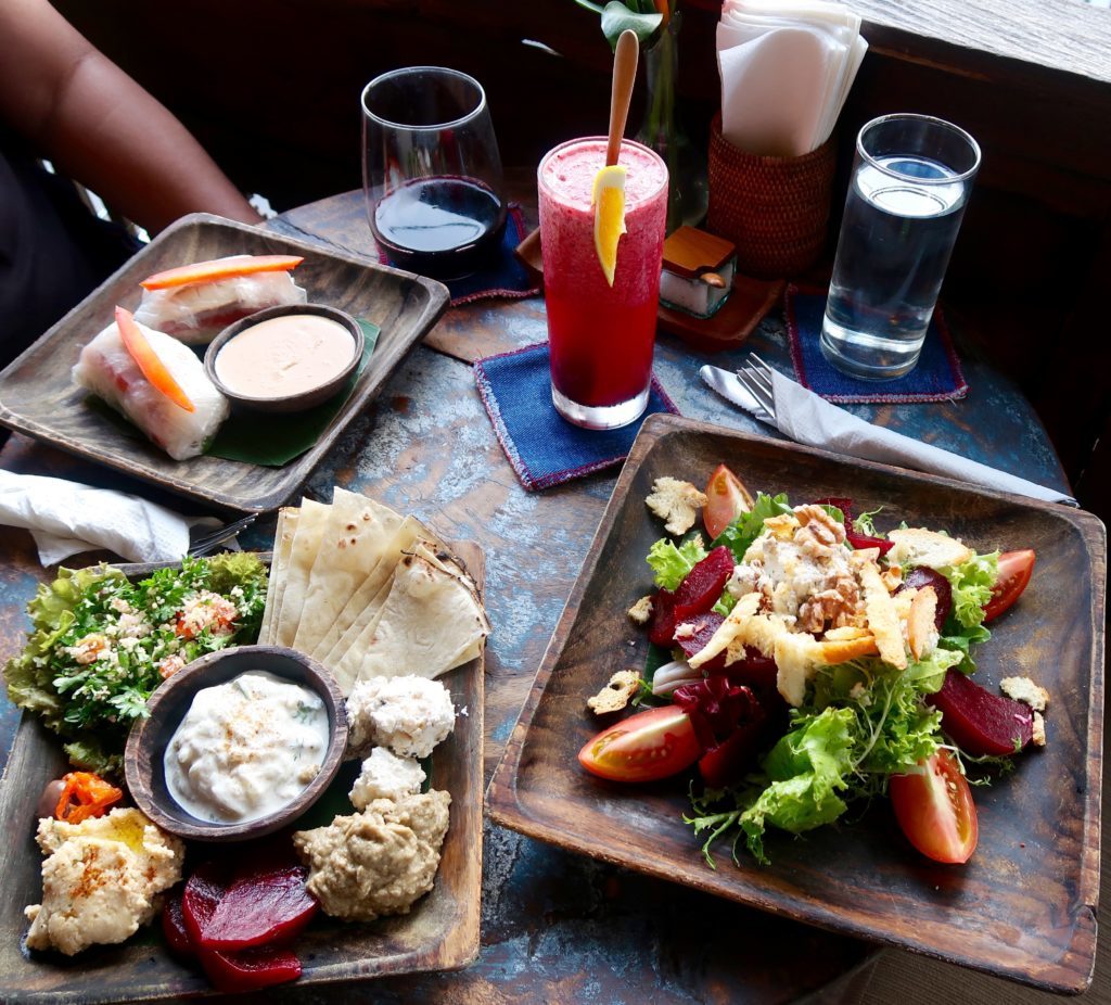 Local dishes on wooden plates at Kafe. Try out their dishes during your one week in Ubud, Bali