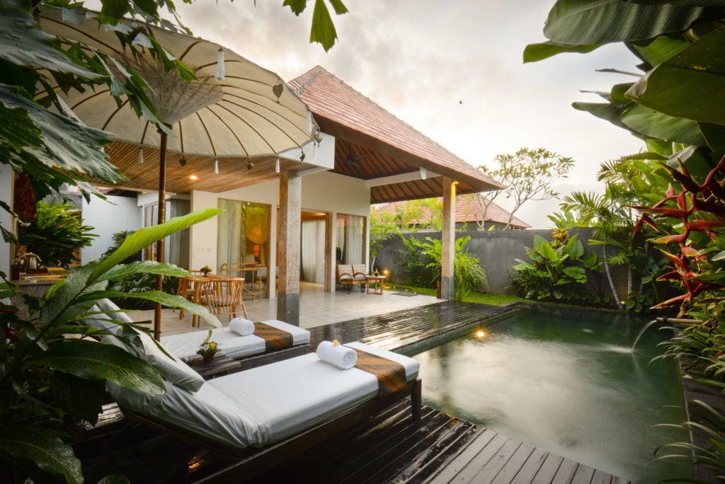 Outdoor lounge beds by a pool at Purana Boutique Resort