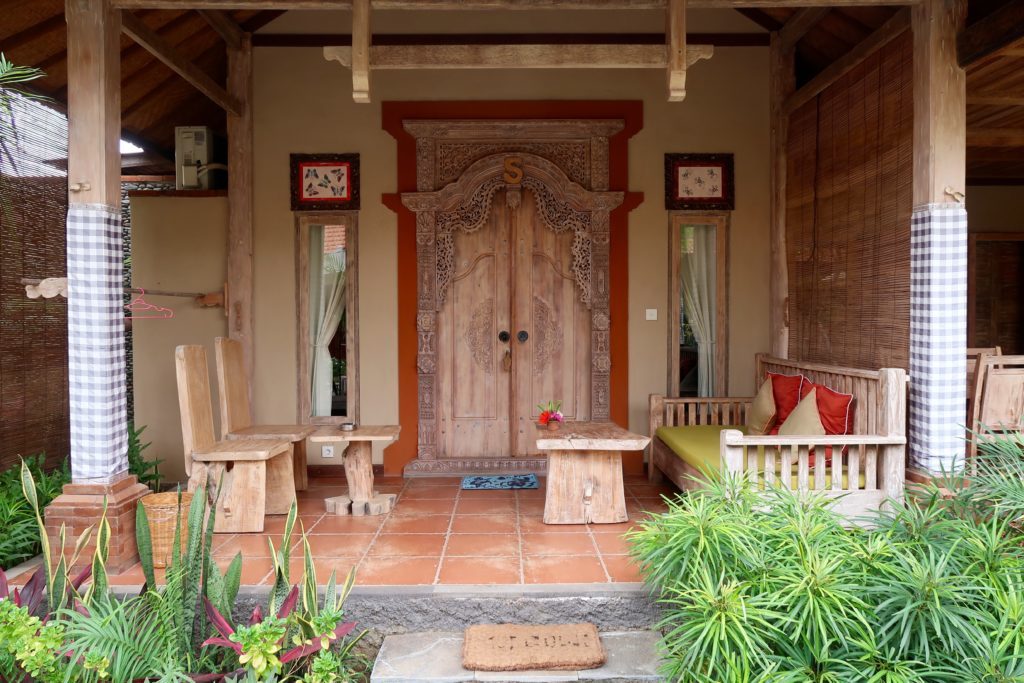 Cozy patio with wooden chairs and tables near the wooden door