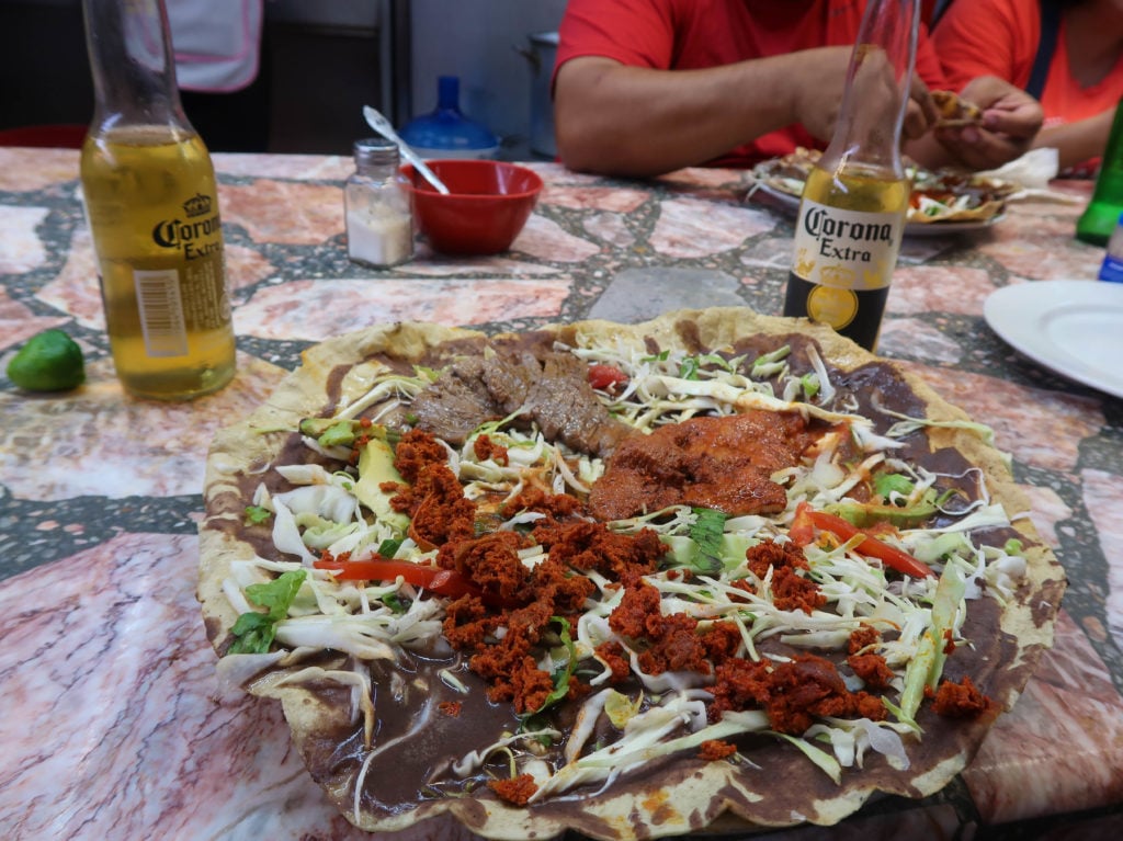 Delicious plate of tlayuda paired with beer