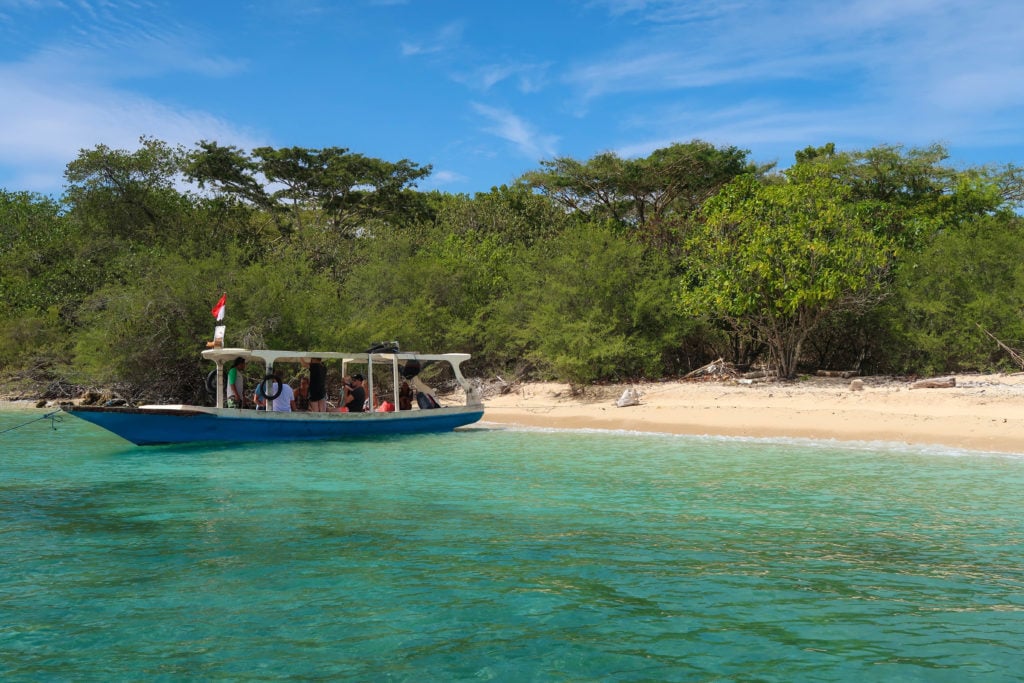 a snorkeling boat anchored by a beautiful beach in Bali