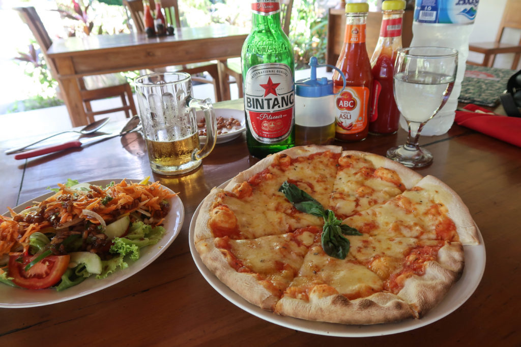 Pizza and salad on table with drinks