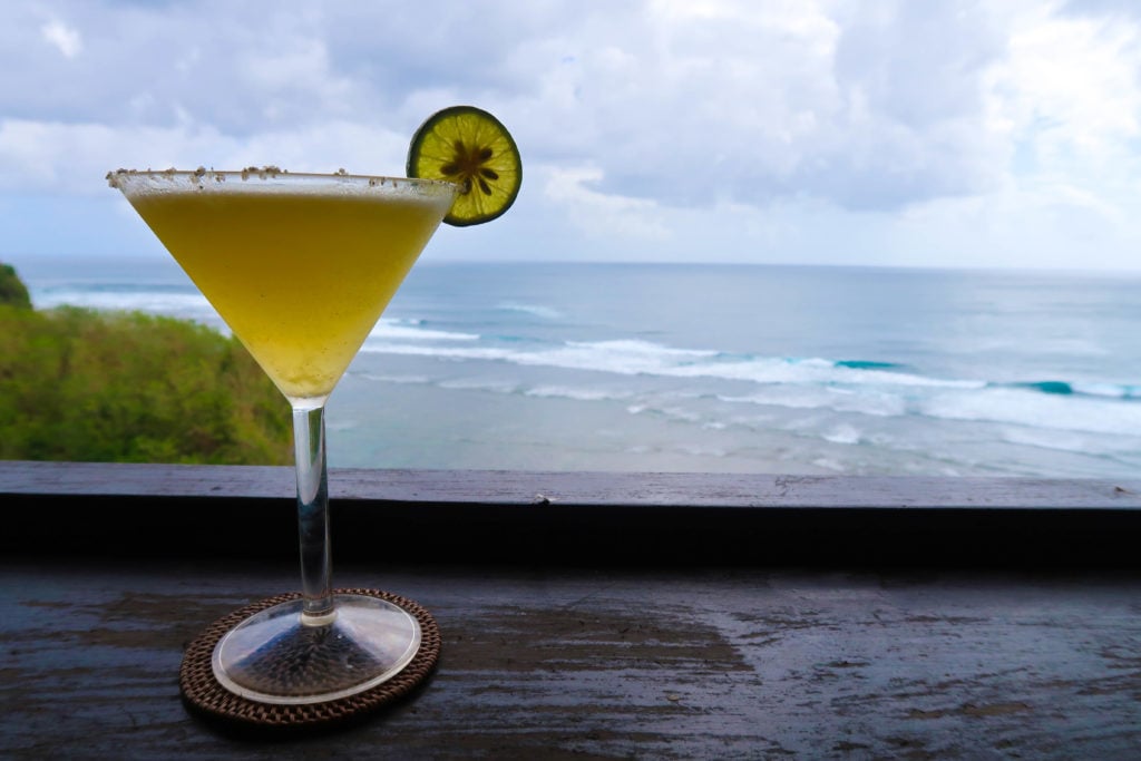 Glass of cocktail with the beautiful beach on the background