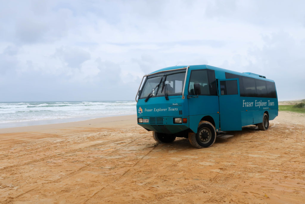 Blue 4WD bus by Fraser Explorer Tours on a sandy beach
