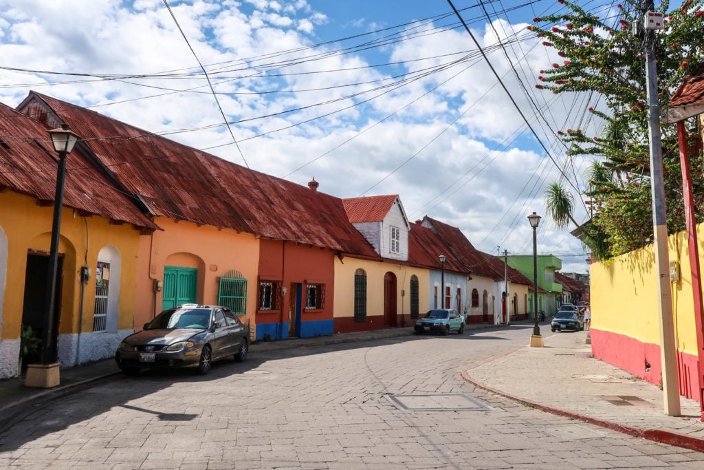 Curved cobblestone street with colorful houses on both sides during daytime