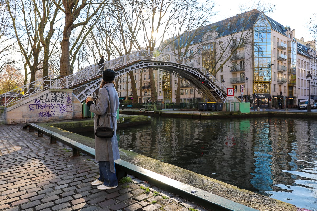 Maddy hanging out by the Canal Saint-Martin, coffee in hand