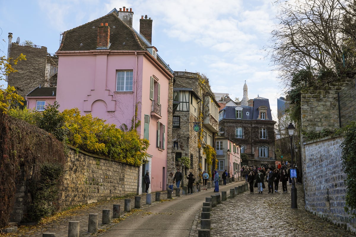 A charming cobblestone street lined by historic buildings in Montmartre, Paris.