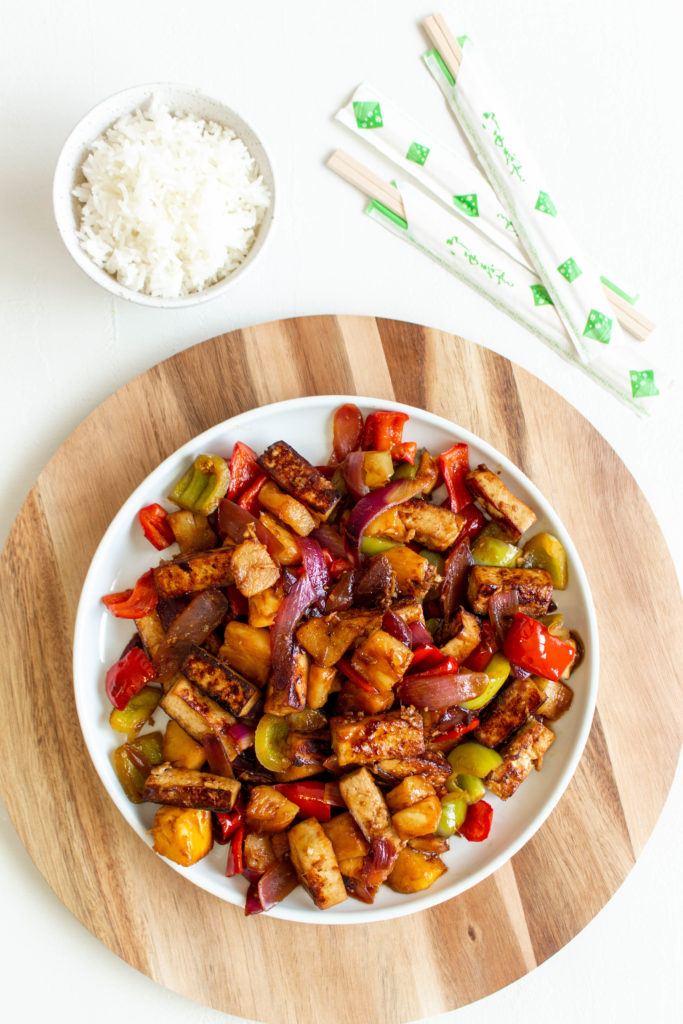 Sweet and Sour Tofu with Pineapple is a vegan version of the classic Chinese-American takeout dish. Marinated crispy tofu, sweet and juicy pineapple, red onion, and green and red bell peppers, all coated in a thick and delicious sweet and sour sauce, is perfect for a quick (35 minutes), super easy, and healthy weeknight meal. Serve it with rice, or even modify the recipe a bit and stir-fry some noodles with it, and you have an epic meal that everyone will love. 