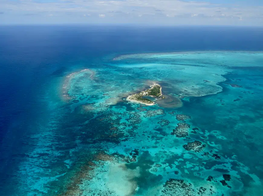 aerial view of a caye in belize - one of the most amazing things to do in Belize is to take a helicopter flight over the reef