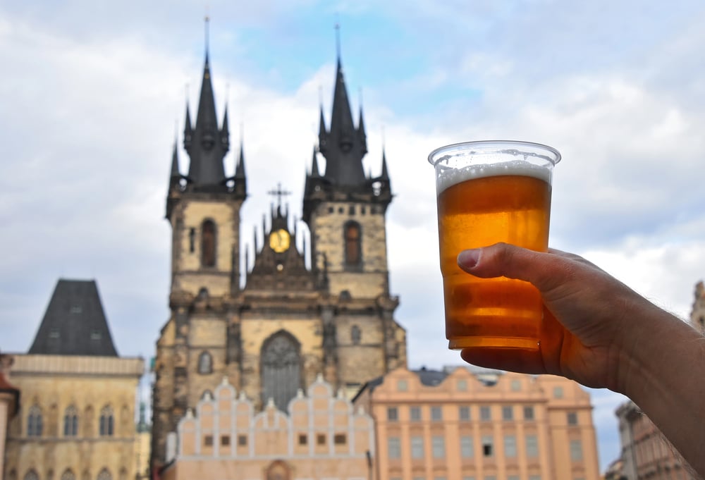 Holding up a beer with the view of the Old Town clock tower in the background