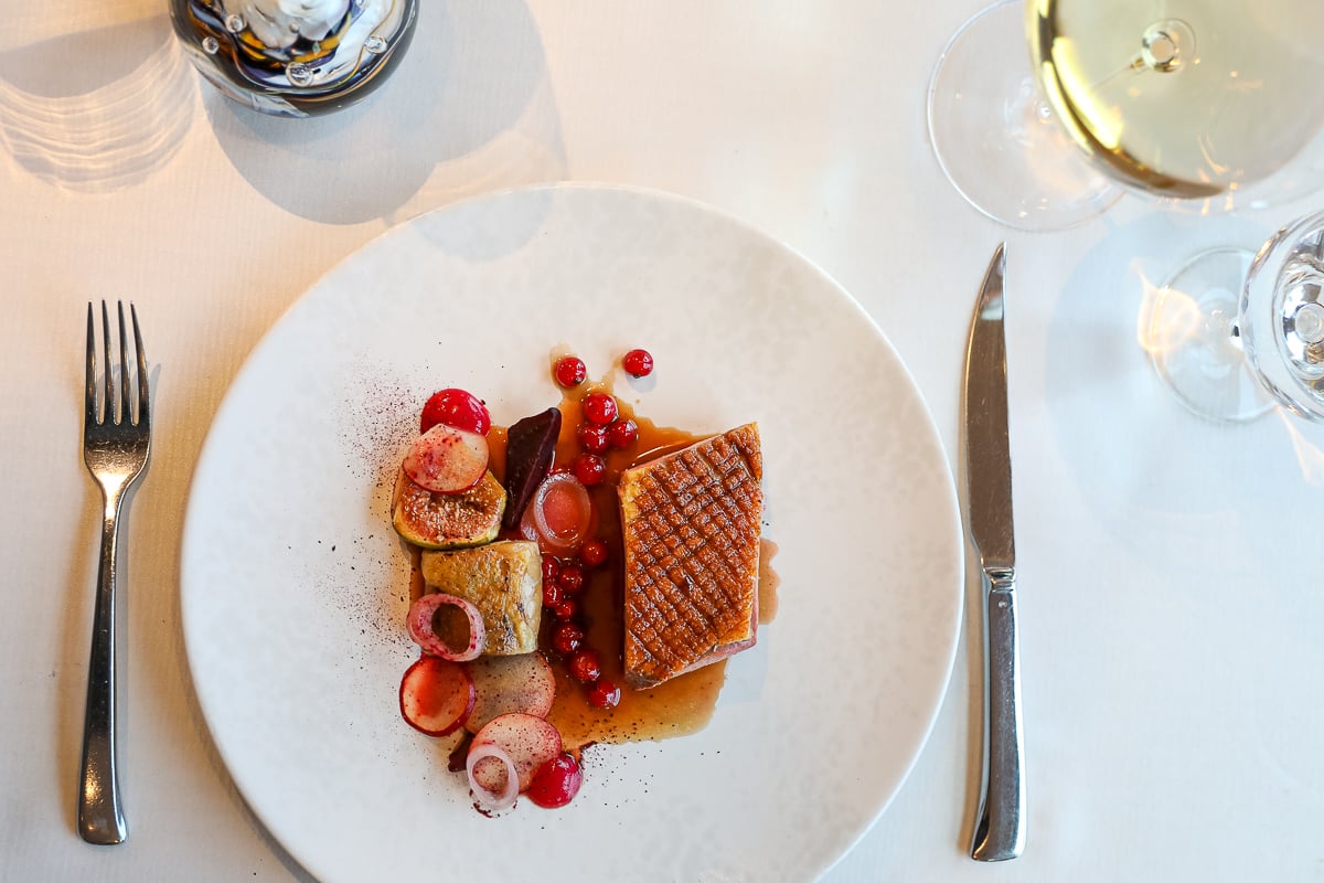 Fine dining dish of roasted duck with figs, beetroot, currants, and hibiscus-thyme jus at Terasa U Zlaté Studně restaurant in Prague.