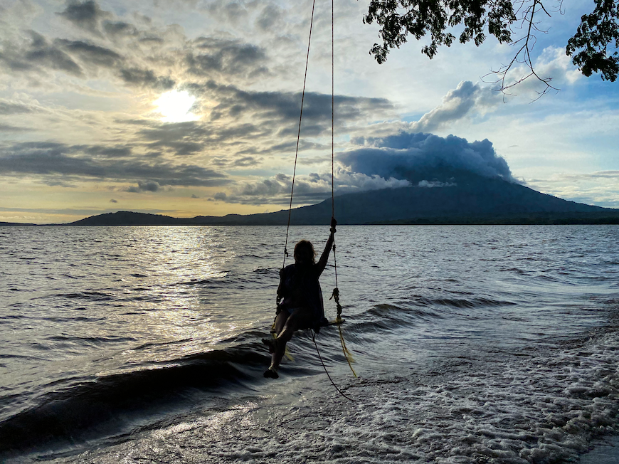 Melanie sitting on a rope swing in Ometepe island looking at the volcano