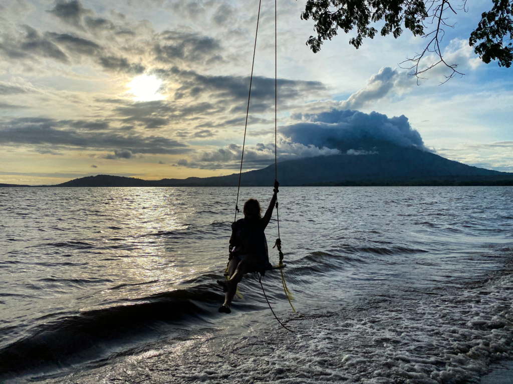 Melanie on rope swing over the lake with Concepcion Volcano in the background