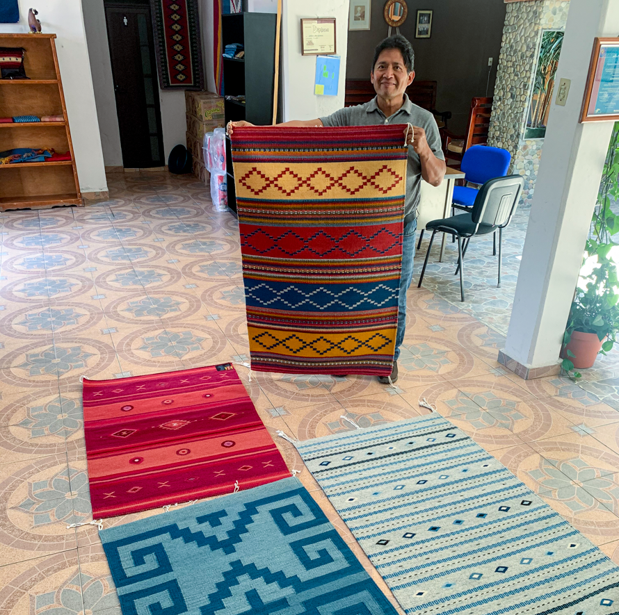 Oaxacan weaver showing off his rugs