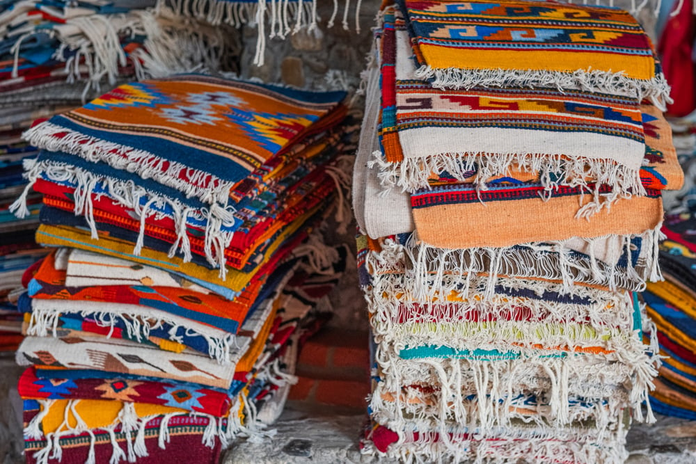 Piles of colorful Oaxacan rugs. Learning about traditional textiles and weaving is one of the top things to do in Oaxaca.