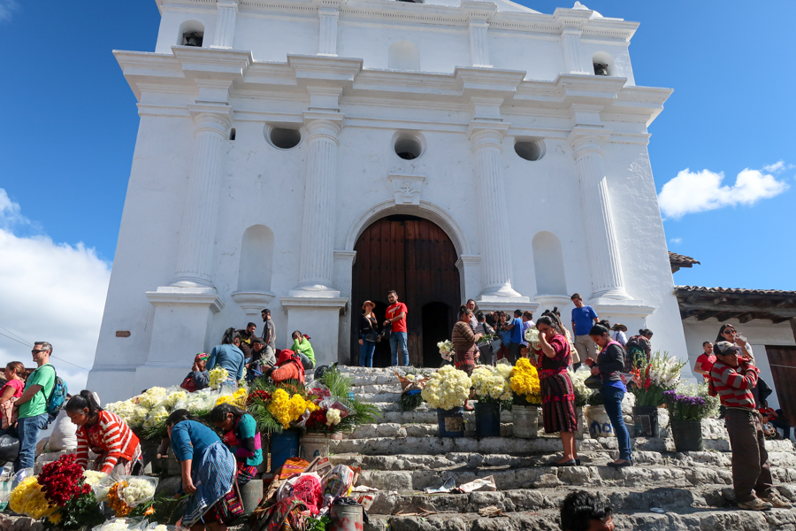 Church in Chichicastenango with people selling flowers on the steps