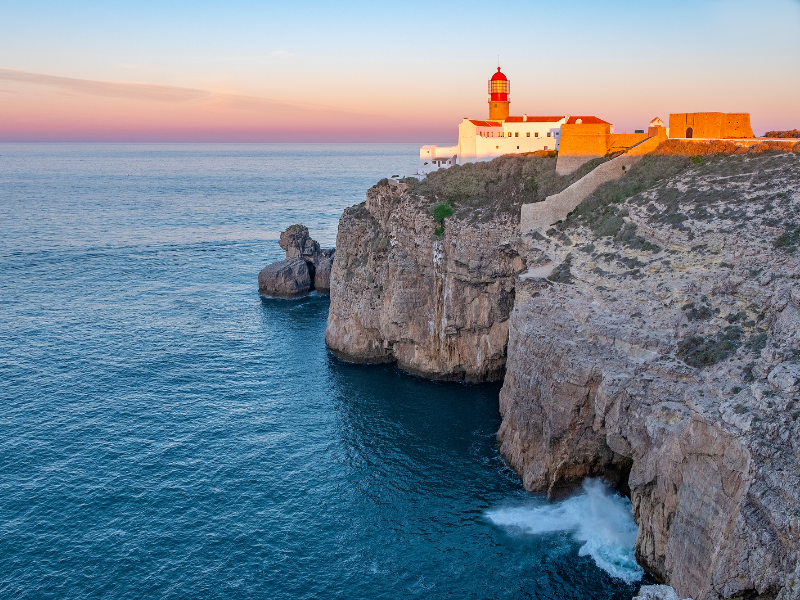 Sunset at a rocky cliff in Sagres, Portugal - seeing a sunset is one of the best things to do in Sagres!