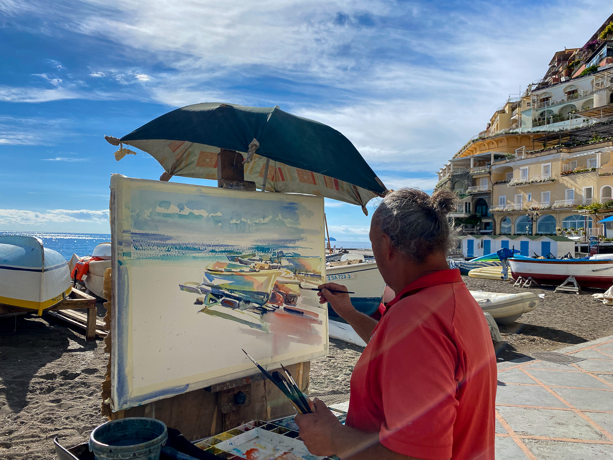 A man painting on the boardwalk in Positano - one of the best Amalfi Coast towns to visit