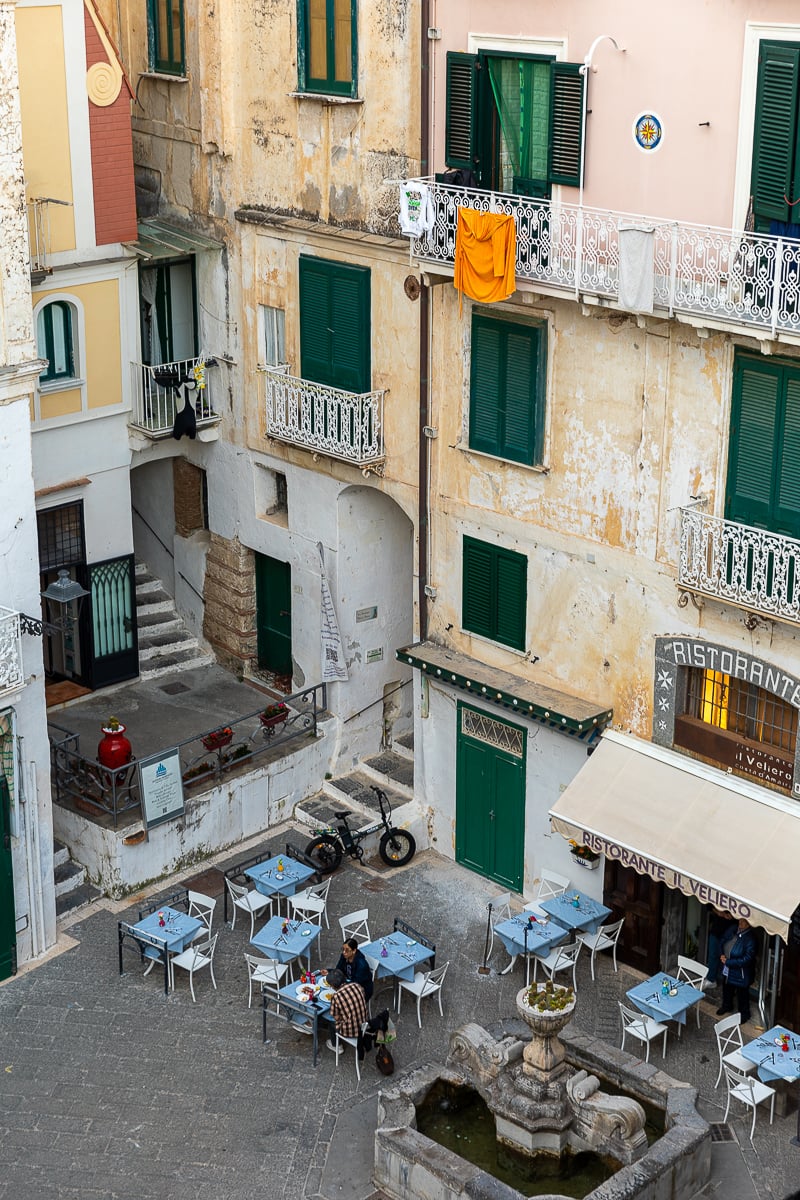 Restaurant surrounded by tall buildings in Atrani